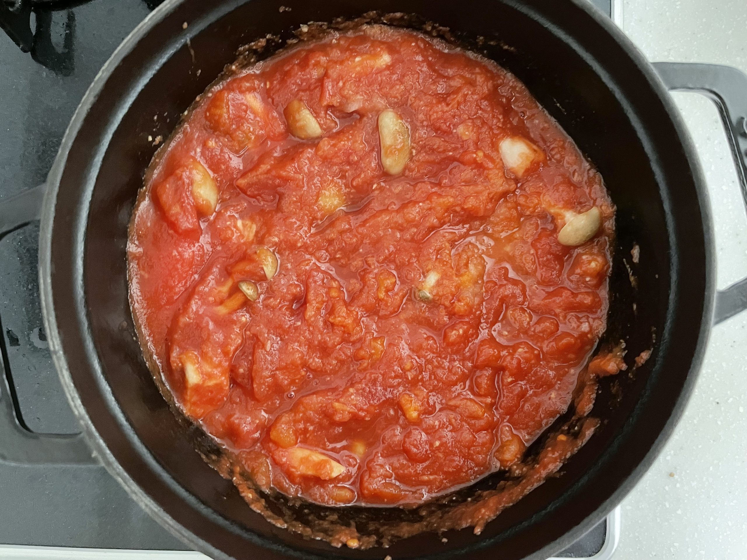 鍋にトマト缶、2、生姜とにんにくを加えて中火でふつふつしてくるまで、混ぜながら煮る。