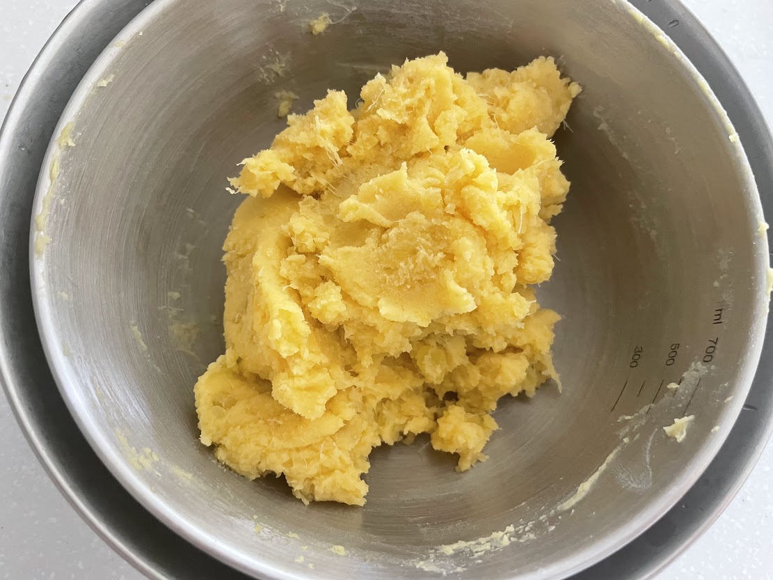 水分がとんだらバターをいれ、溶けてなじんだら火を止め、卵黄1〜1.5個分を入れ混ぜる。<br />
混ざったらボウルに移し、氷水に当てて冷ます。