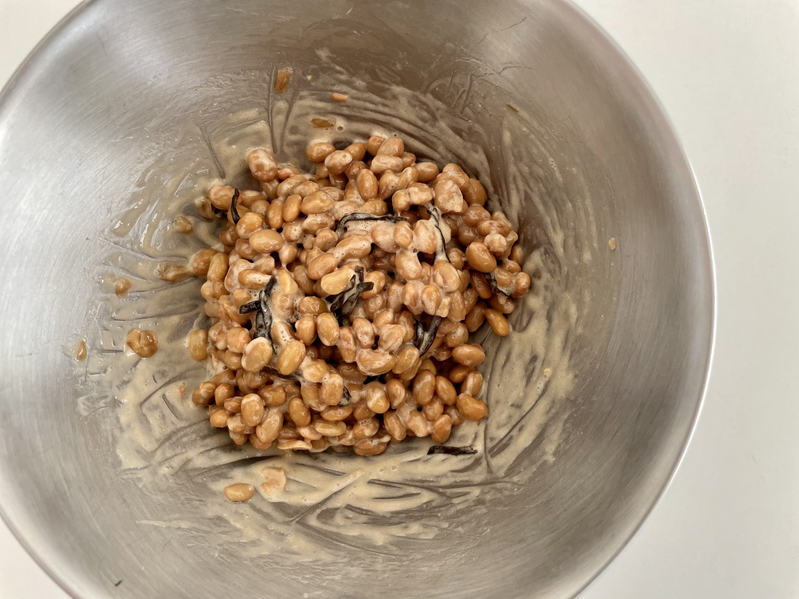 納豆をボウルに移し、粘り気が出るまで混ぜる。<br />
そこへ塩昆布と醤油を入れて更に混ぜる。<br />