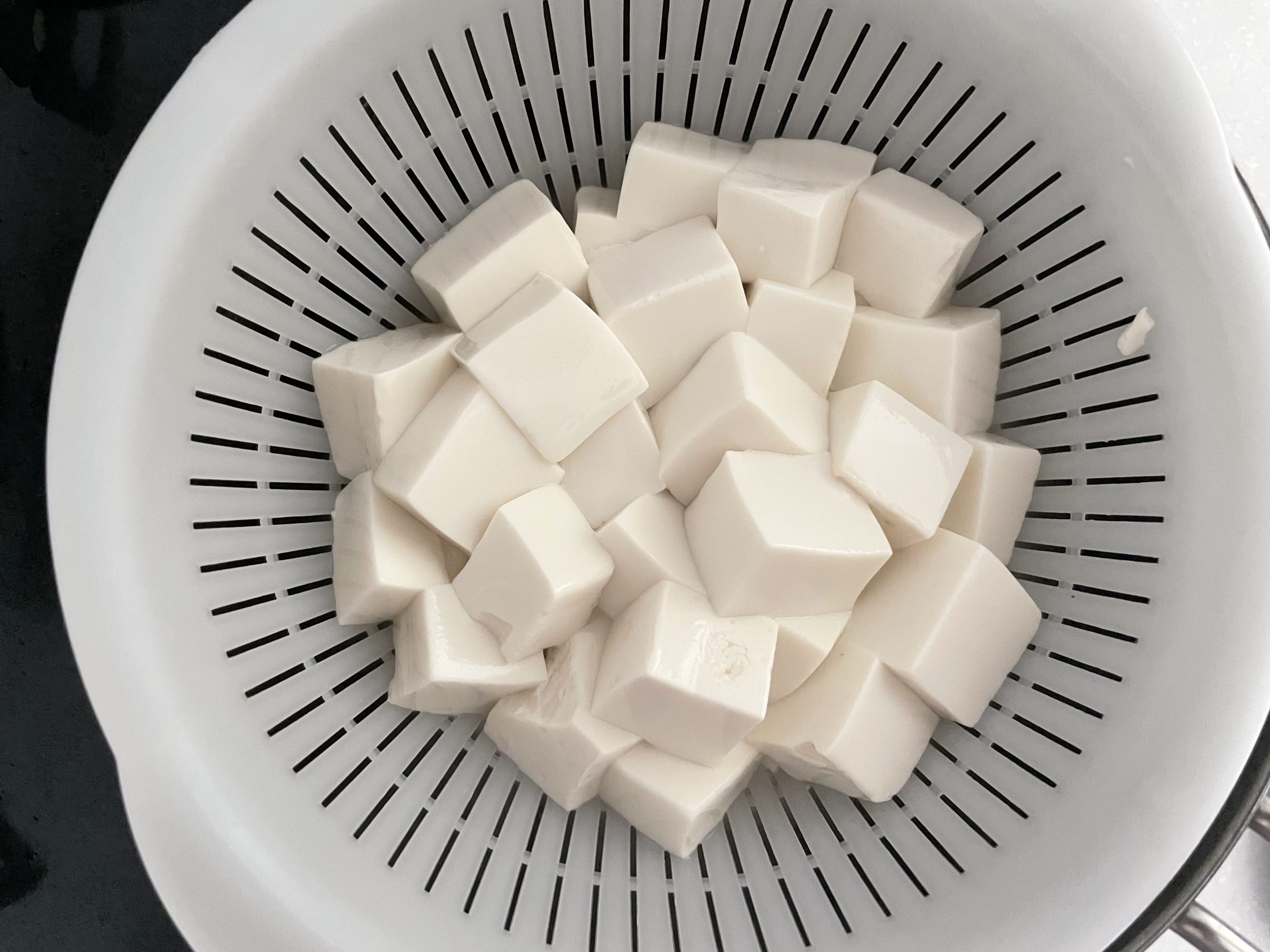 別の鍋に水を沸騰させ、塩(分量外)を入れ、豆腐をゆでる。弾力がでてきたら引き上げる。
