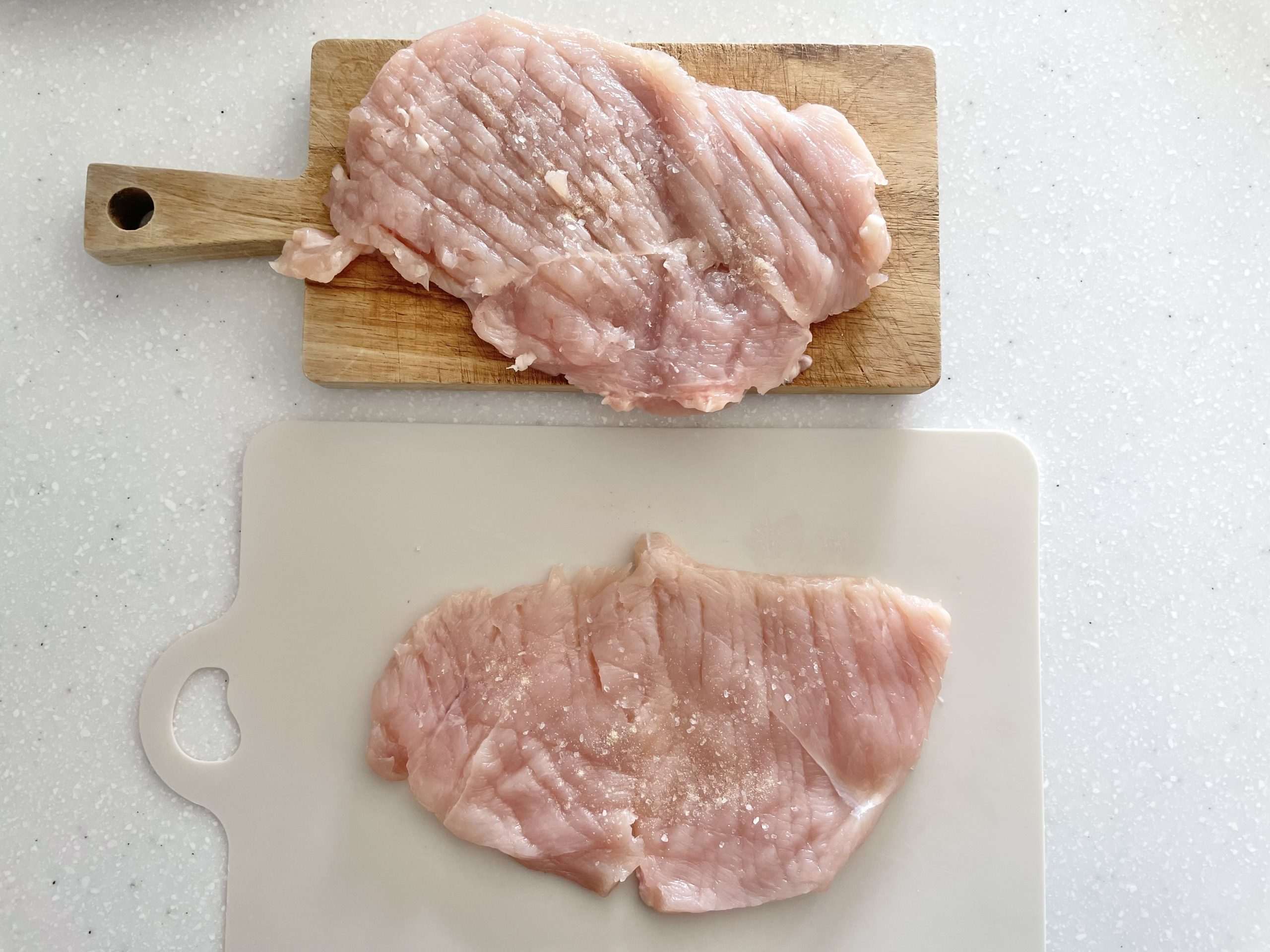 【下準備】鶏むね肉の皮を剥ぎ半分に切り、真ん中に切り込みを入れて開いたら両面を包丁の裏で叩いて伸ばす。開いた面に塩胡椒を振っておく。