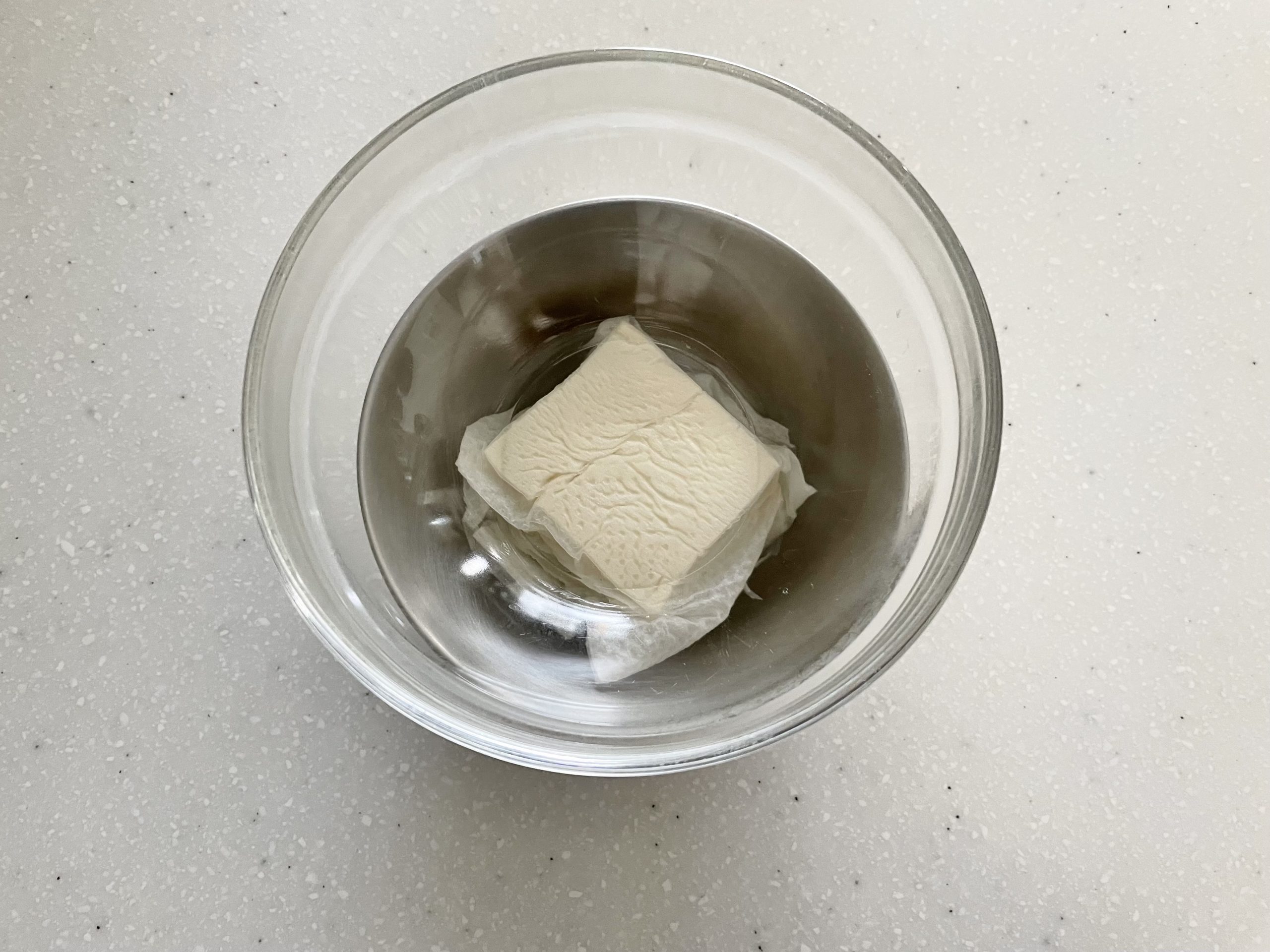 絹ごし豆腐はキッチンペーパーで包んで、重しをのせて水切りしておく。